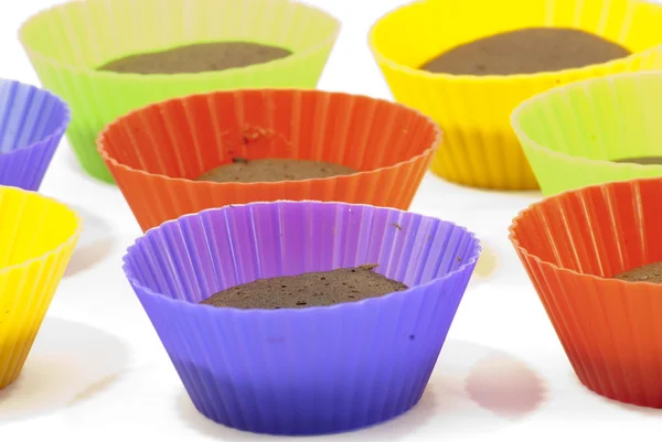 Chocolate muffins in silicone holders of many colors — Stock Photo, Image