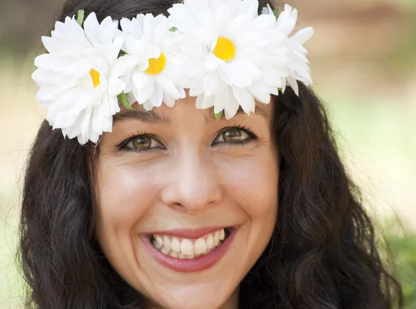 Hermosa mujer con una corona de flores blancas en su cabeza en un — Foto de Stock