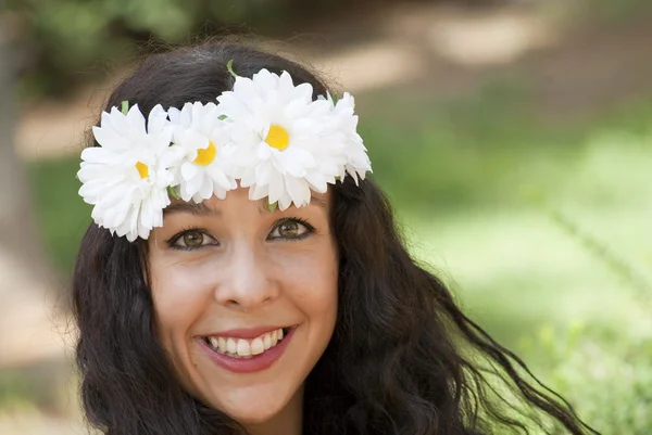 Mooie vrouw met een krans van witte bloemen op haar hoofd in een — Stockfoto