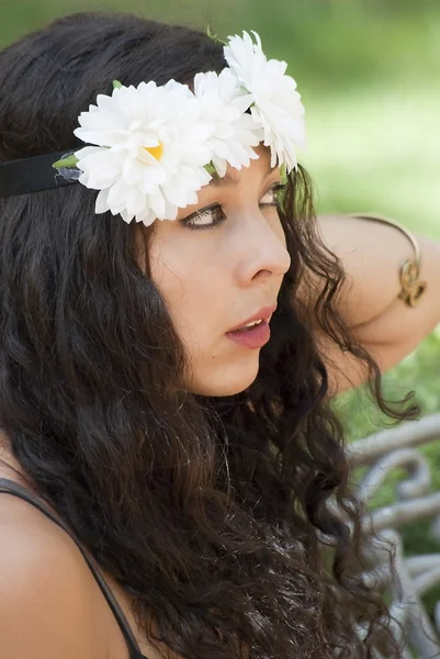 Mooie vrouw met een krans van witte bloemen op haar hoofd in een — Stockfoto