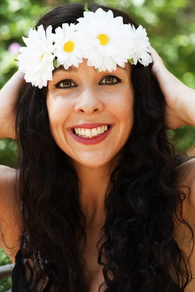 Vacker kvinna med en krans av vita blommor på hennes huvud i en — Stockfoto