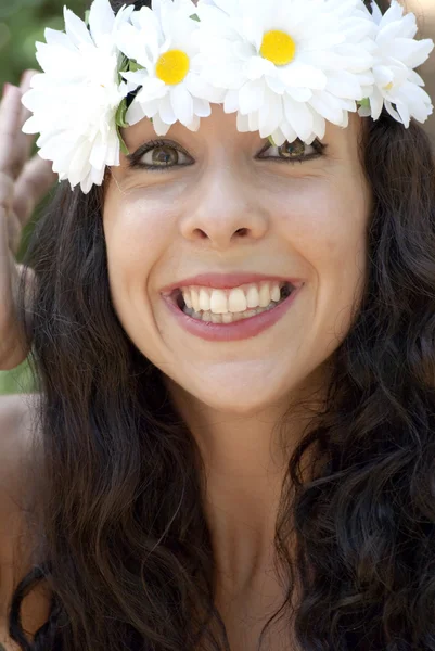 Vacker kvinna med en krans av vita blommor på hennes huvud i en — Stockfoto