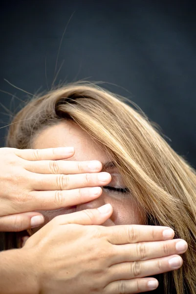 Bella donna con due mani che coprono il viso — Foto Stock