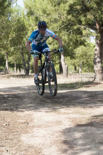 Ciclista en carreras de bicicleta de montaña haciendo una carrera en el campo — Foto de Stock