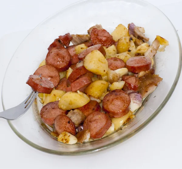 Plate of pieces of sausage, potatoes, garlic and meat with a pie — Stock Photo, Image