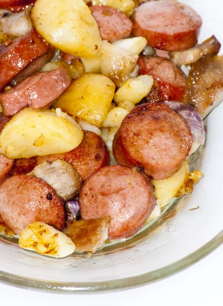 Platta av bitar av korv, potatis, vitlök och kött — Stockfoto