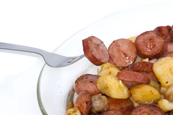 Bord met stukjes worst, aardappelen, knoflook en vlees met een taart — Stockfoto