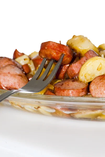 Bord met stukjes worst, aardappelen, knoflook en vlees met een taart — Stockfoto