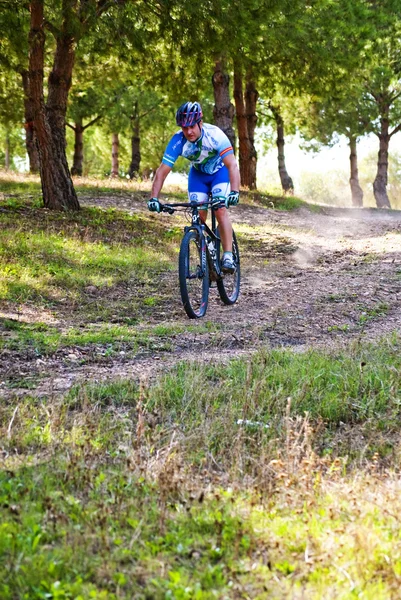 Ciclista en carreras de bicicleta de montaña haciendo una carrera en el campo — Foto de Stock