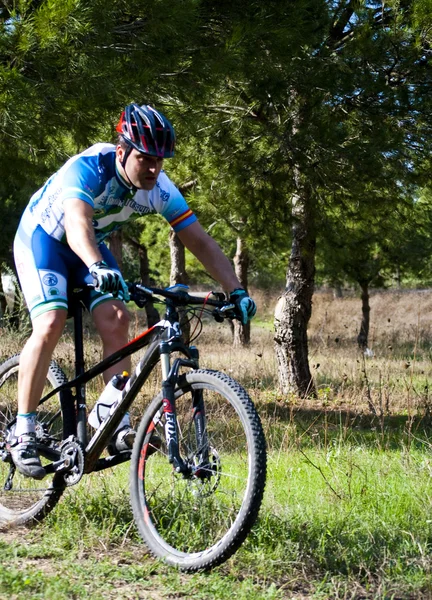 Ciclista en carreras de bicicleta de montaña haciendo una carrera en el campo — Foto de Stock