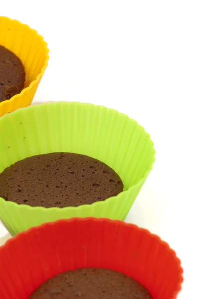 Chocolate muffins in silicone holders of many colors — Stock Photo, Image