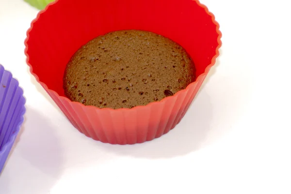 Chocolate muffins in silicone holders of many colors — Stock Photo, Image