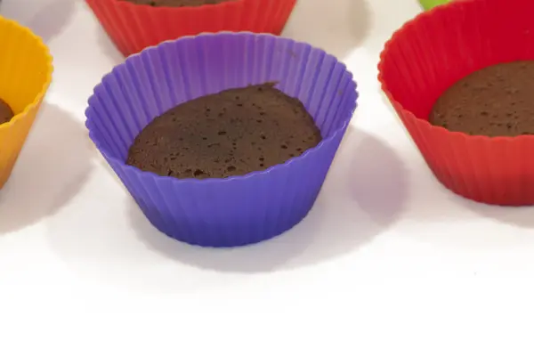 Chocolate muffins in silicone holders of many colors — Stock Photo, Image