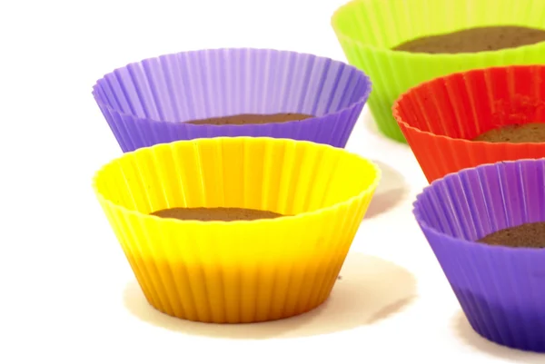 Chocolate muffins in silicone holders of many colors — Stock Photo, Image