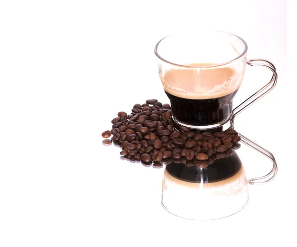 Koffiekopje en koffie bonen op een spiegel — Stockfoto