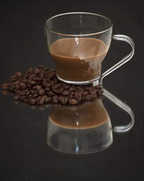 Koffiekopje en koffie bonen op een spiegel — Stockfoto