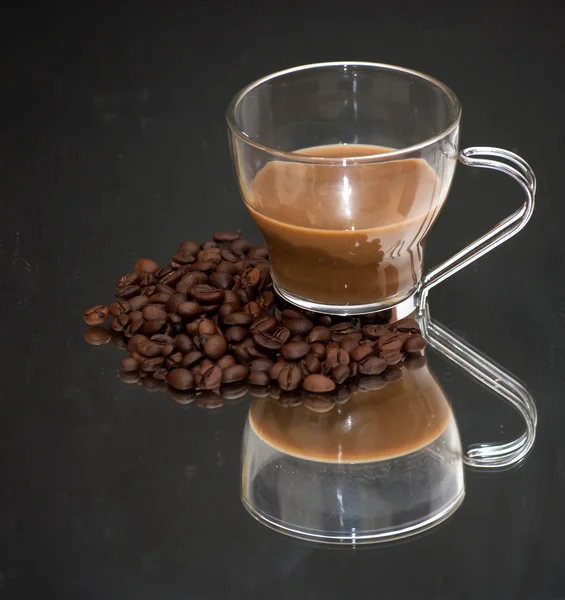 Taza de café y granos de café en un espejo —  Fotos de Stock