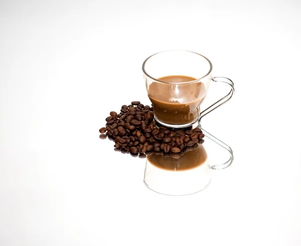 Tasse à café et grains de café sur un miroir — Photo