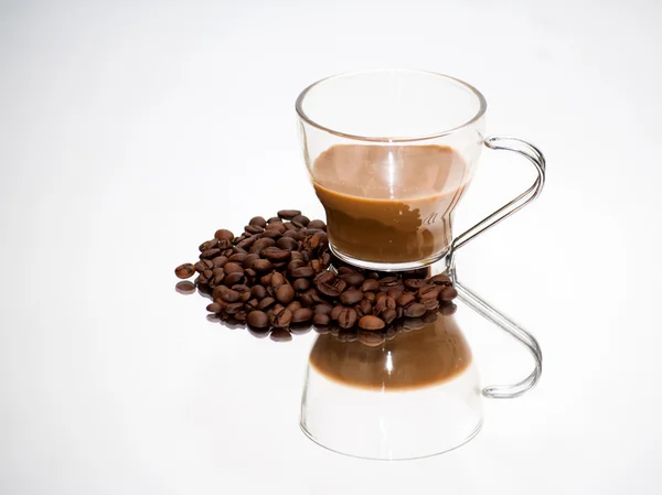 Taza de café y granos de café en un espejo — Foto de Stock