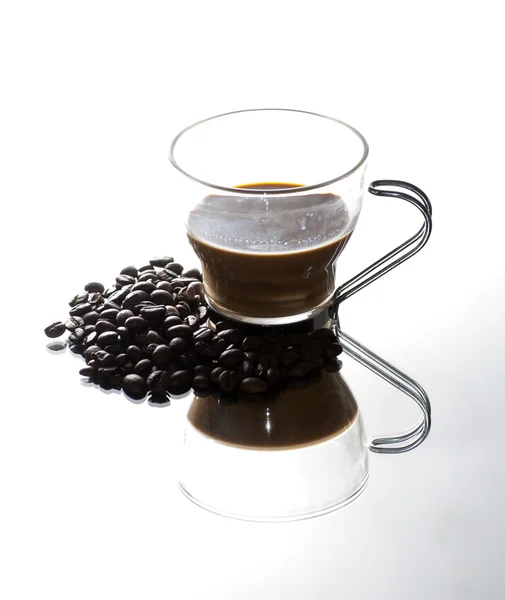 Tasse à café et grains de café sur un miroir — Photo