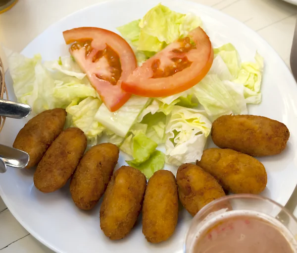 Bowl of croquettes, salad, beer, snacks and chips — Stock Photo, Image