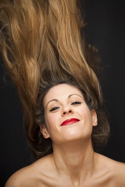Smuk kvinde ryster hendes hår - Stock-foto