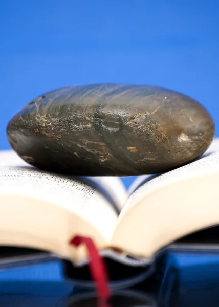 Книга открыта с одним камнем на ней — стоковое фото