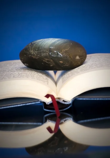 Libro abierto con una sola piedra en él — Foto de Stock