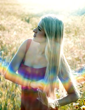 Gün batımında buğday alanında güzel sarışın kadın