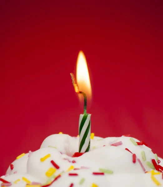 Кекс с зажженной свечой — стоковое фото