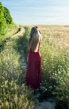 güzel sarışın kadın da bir buğday alanı içine bir yolu