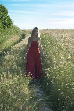 güzel sarışın kadın da bir buğday alanı içine bir yolu
