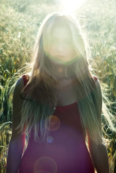 Vacker blond kvinna i ett vete fält vid solnedgången — Stockfoto