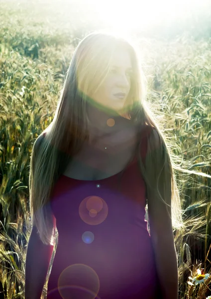 Belle femme blonde dans un champ de blé au coucher du soleil — Photo