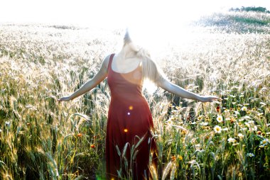 Gün batımında buğday alanında güzel sarışın kadın