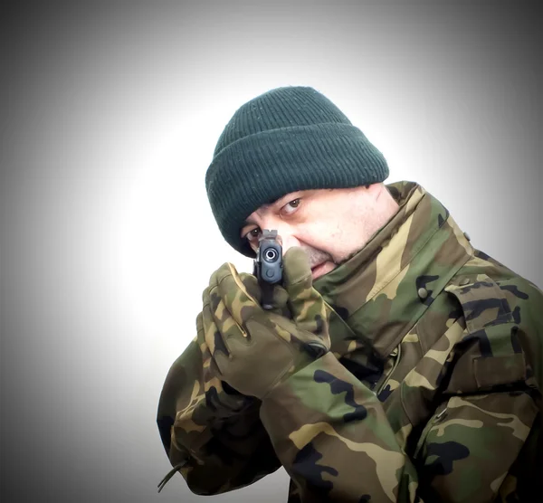 Voják se zbraní a maskovací oblek — Stock fotografie