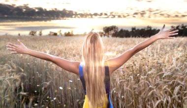 Gün batımında buğday alanında güzel sarışın kadın