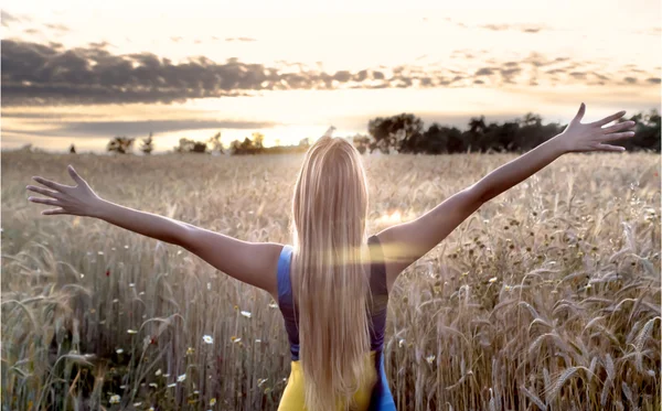 Krásná blondýnka v pšeničné pole při západu slunce — Stock fotografie