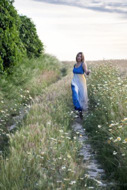 Bir buğday alanında bir yolda güzel sarışın kadın 