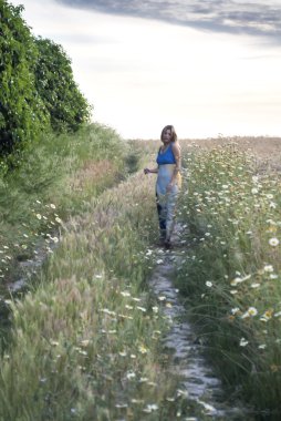 Bir buğday alanında bir yolda güzel sarışın kadın 