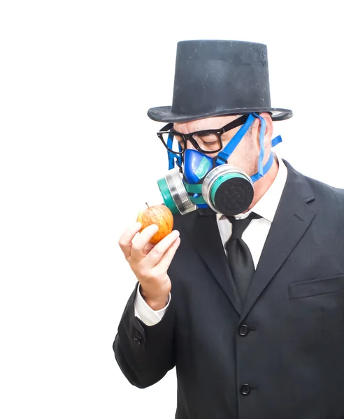 Empresario con máscara de gas y sombrero mirando una manzana — Foto de Stock