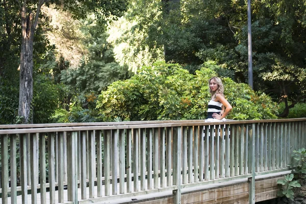 Mooie vrouw op een houten brug In The Park — Stockfoto