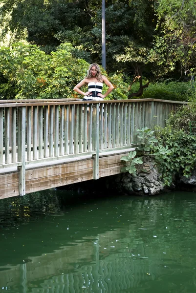 Красивая женщина на деревянном мосту в парке — стоковое фото
