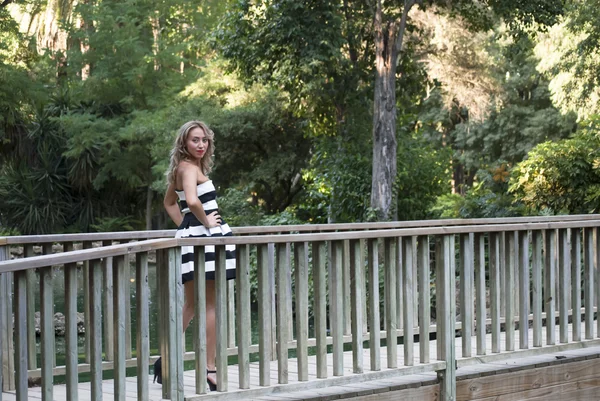美丽的女人，在一座小木桥在公园里玩 — 图库照片