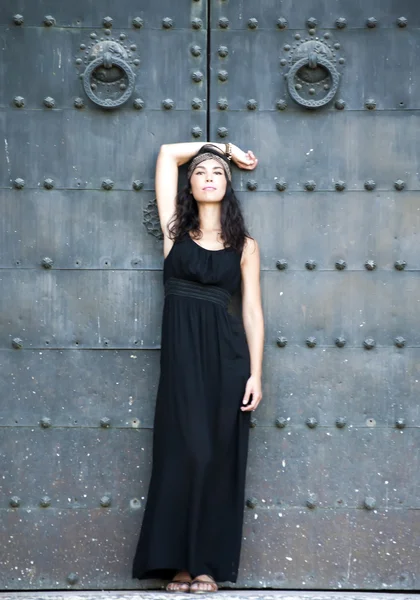 Mulher bonita na frente de uma porta velha — Fotografia de Stock