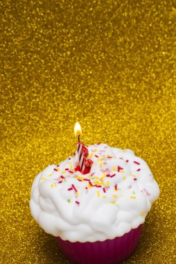 Cupcake parlak arka plan üzerinde yanan bir mum ile