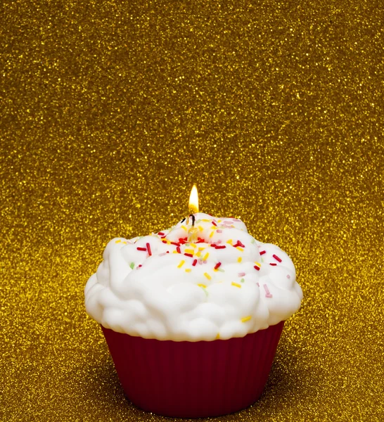 Cupcake parlak arka plan üzerinde yanan bir mum ile — Stok fotoğraf