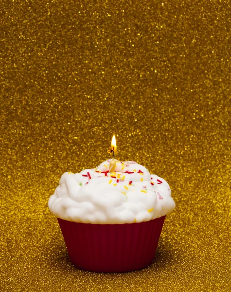 Cupcake com uma vela acesa sobre fundo brilhante — Fotografia de Stock