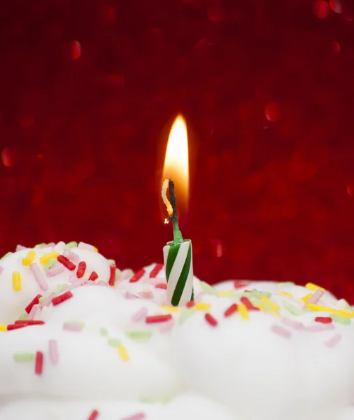 Cupcake con una candela accesa su sfondo rosso brillante — Foto Stock