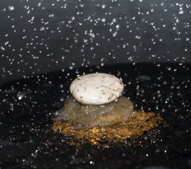 Taşları üzerine düşen su damlaları